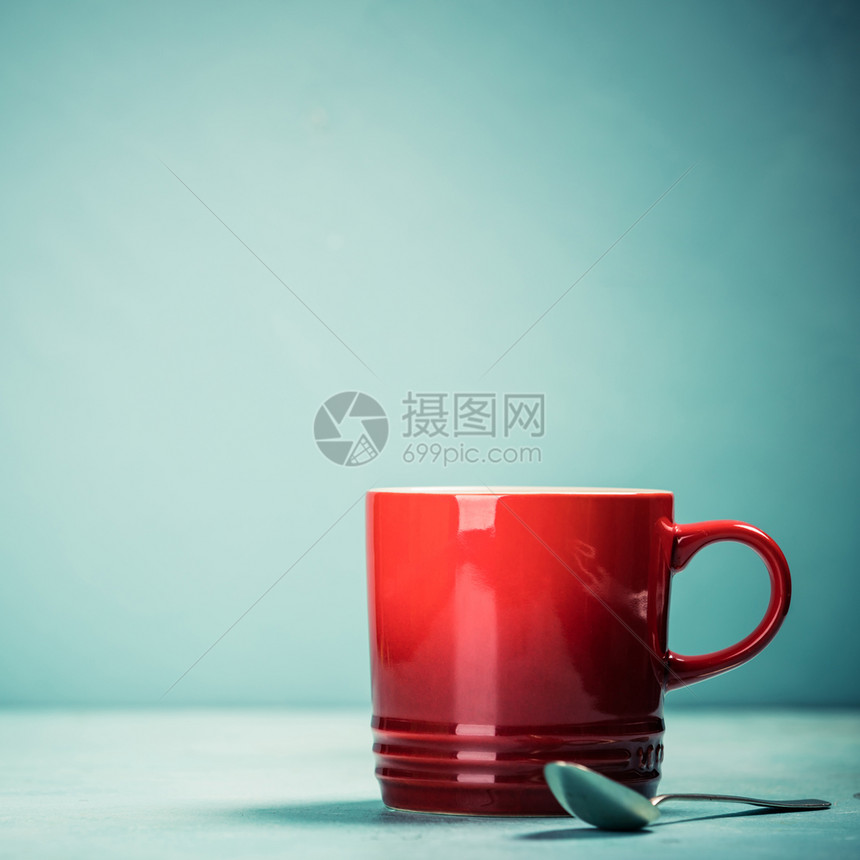 蓝色背景的红咖啡杯或茶蓝色背景的红杯文本空间图片