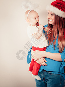 穿着圣达克萨斯帽和小宝的女人圣诞节和孩子图片