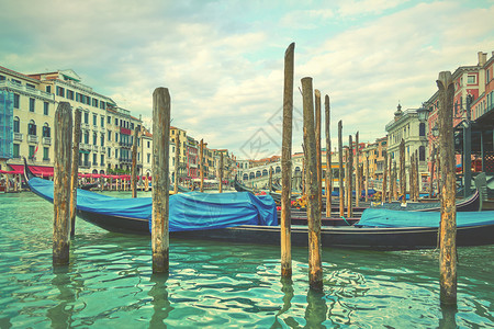 威尼斯Rialto桥附近的大运河与意利的Gondolas系住图片