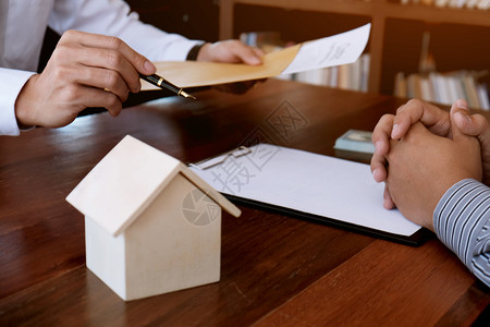 商业人员与房地产代理商签订交易合同顾问概念和家庭保险已婚的高清图片素材