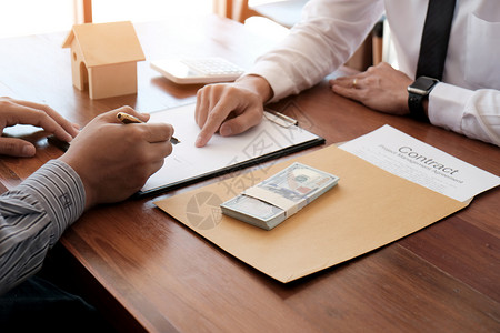 商业人员与房地产代理商签订交易合同顾问概念和家庭保险签字高清图片素材