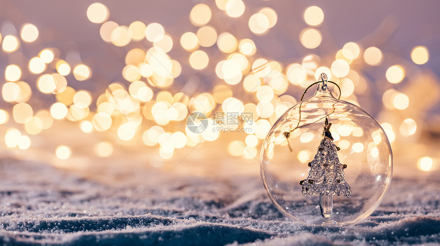 圣诞玻璃球里面有树在冬天背景雪和圣诞节的灯光圣诞节玻璃球里面有树在冬天背景图片