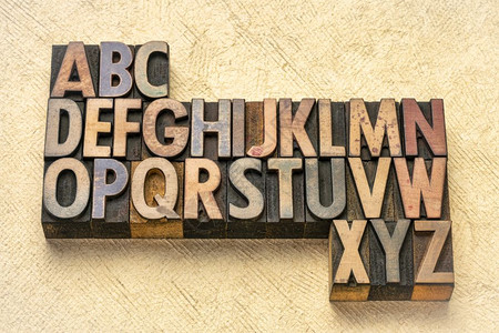 与纹理树皮纸相比的旧印刷木型打块中的抽象字母木材高清图片素材