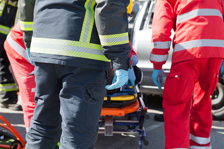 救援队员车祸后救援行动中的辅助医务人员和消防人员背景