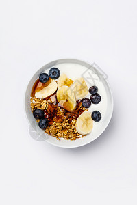 健康素早餐新鲜蓝莓香蕉豆酸奶和红糖浆白底平地顶楼有新鲜蓝莓大豆酸奶和糖浆特写镜头高清图片素材