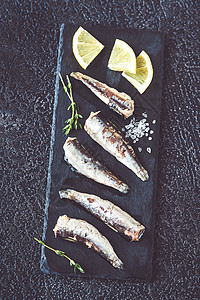 黑鲹和沙丁鱼黑石板上的沙丁鱼最高视图背景