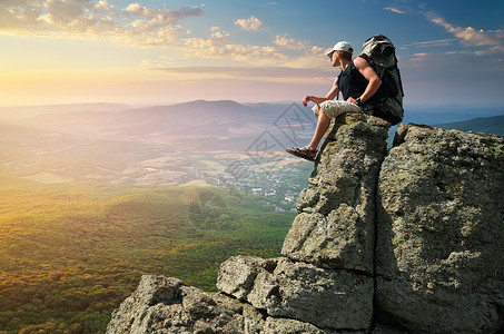 人坐在山顶上岩石图片