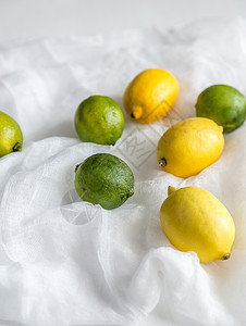 白纱布上的青柠檬和黄柠檬背景图片