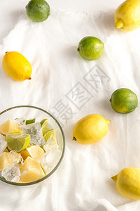 白纱布上的玻璃杯和柠檬背景图片