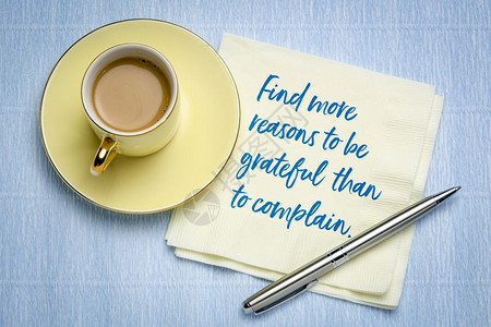 比抱怨更值得感激在餐巾纸上写有灵感的笔迹加上一杯咖啡图片