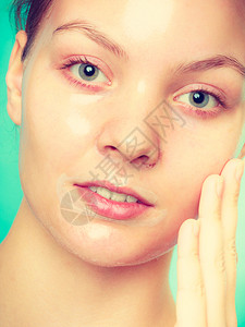 脸部剥皮的年轻女面部剥皮的年轻女肤美容和护理工作室拍摄绿色图片
