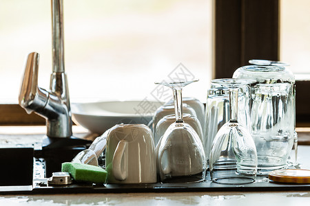 现代水槽和厨房柜台里面装有锁的餐具窗子在幕后洗干净厨房水槽和餐具图片