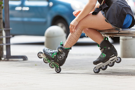 妇女穿着溜冰鞋在城里坐着夏季妇女运动很活跃背景图片