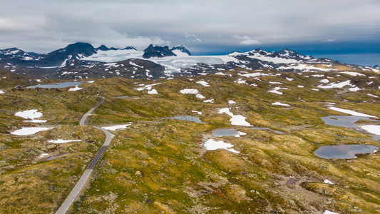 穿越山地的公路远处雪峰和冰川旅游景点5Sognefjellet挪威空中视图山地景观挪威路线Songnefjellet软果冻高清图片素材