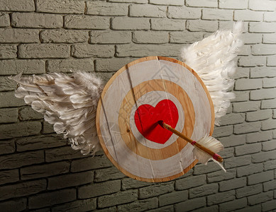 粗木制目标的抽象图像其符号是心脏象征着对灰砖墙的刺穿箭头爱图片