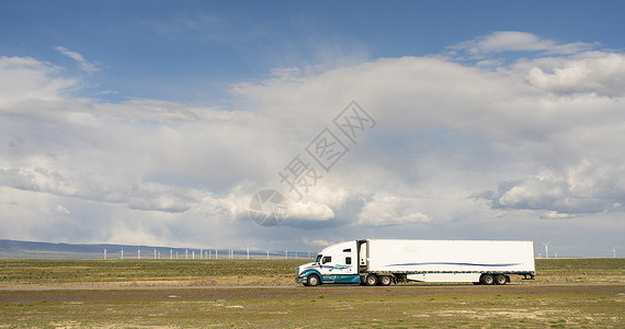 在犹他州公路上挂有货运集装箱的白色大卡车图片