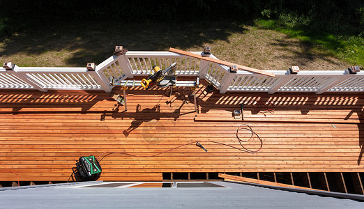 在地板上用电和手工具改造户外木甲板的顶部视图背景图片