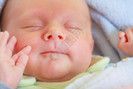 婴儿护理童年概念的美丽小新生婴儿在床上安睡被毯子包围小新生婴儿在毯子中安睡面对高清图片素材