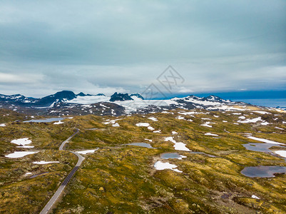 穿越山地的公路远处雪峰和冰川旅游景点5Sognefjellet挪威空中视图山地景观挪威路线Songnefjellet夏季高清图片素材