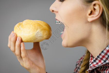 拥有面包卷的妇女享受健康早餐小麦食品面包图片