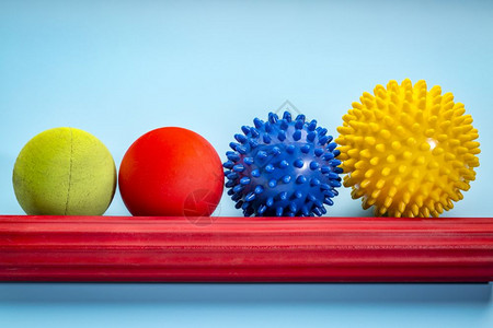 自我按摩和反光学治疗概念一套蓝色背景的小型橡胶球和滚筒棒图片