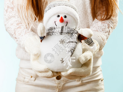 女孩拿着羊毛白手套圣诞节时间概念女孩拿着雪人图片