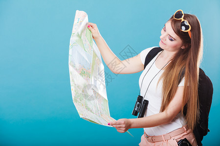 暑假和旅游概念有吸引力的年轻女子长发太阳镜背包蓝色阅读图片