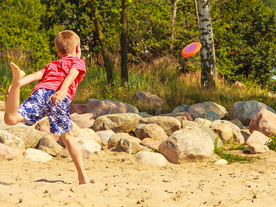 海滩上小男孩在开心的玩飞盘图片