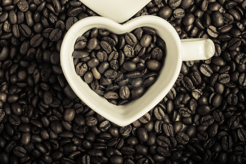 咖啡时间白色杯子以烤咖啡豆背景的心形最佳色黑白相片图片