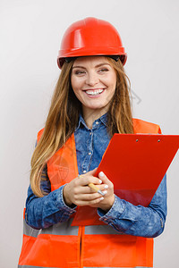 妇女建筑工人结构程师穿橙色背心红头盔有笔文件垫工业作安全室拍摄灰色女工程师建筑头盔防护的高清图片素材