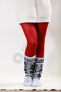 冬季时穿冬服装的女子双腿羊毛暖和袜子红色紧身裤穿羊毛袜子和红色紧身裤的女子双腿背景图片