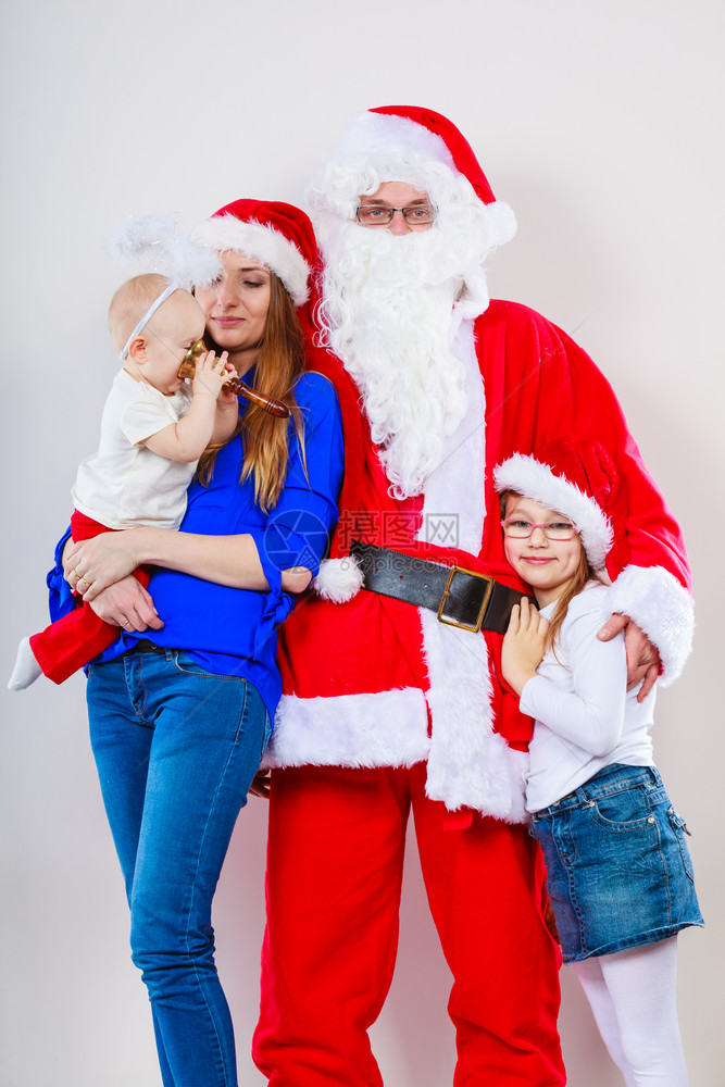 圣诞节家庭概念母亲幼儿婴和穿着圣诞老人服装的男母亲圣诞老人和两个女儿的圣诞节家庭照片图片