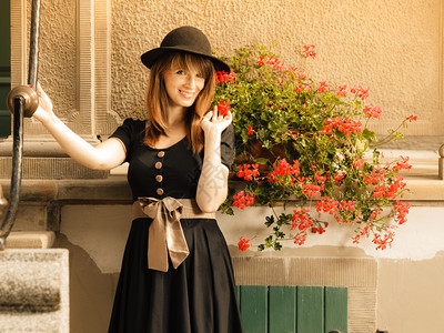穿黑帽子的女时装郎穿着黑帽子的时装女郎在旧城波兰格丹斯克泽街上穿着衣服背景图片