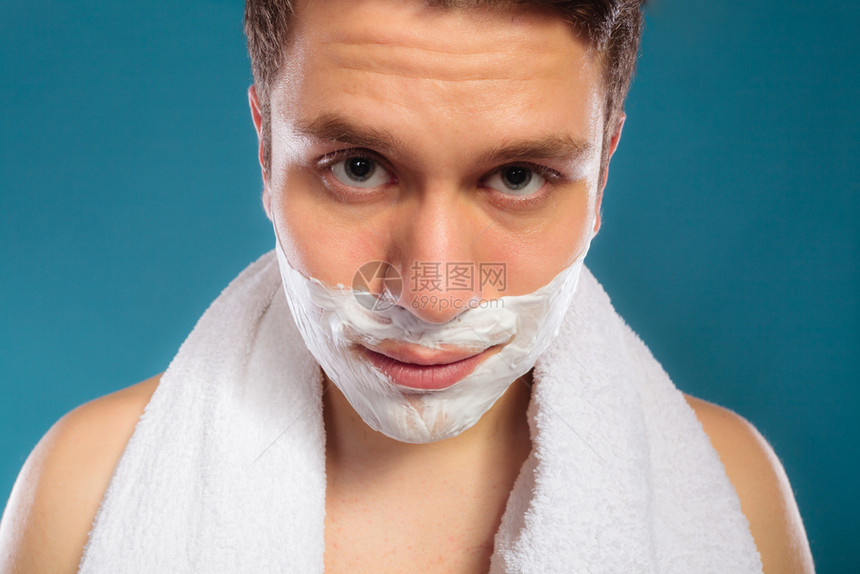 长着剃须奶油泡沫和白毛巾的年轻人准备刮胡子的帅哥皮肤护理和卫生长着剃须奶油泡沫的帅哥图片
