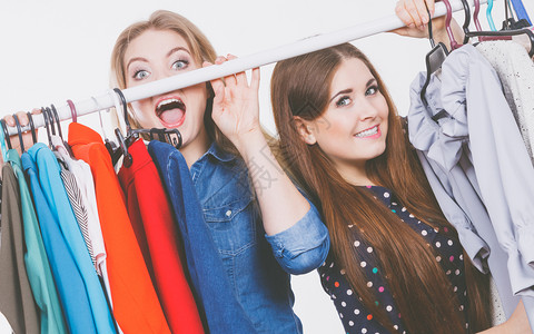 快乐的年轻女子在购物时挑衣服穿尚装快乐的女子买衣服吊架高清图片素材