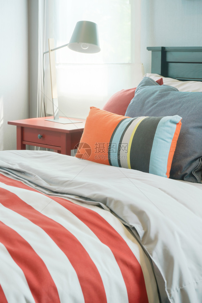 现代室内卧带红色条纹毯子的多彩枕头图片