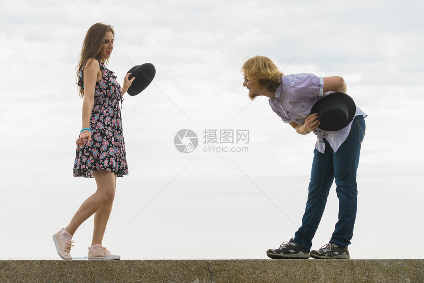 男女在外边享受浪漫的约会穿着Fedora的帽子和在海边跳舞图片