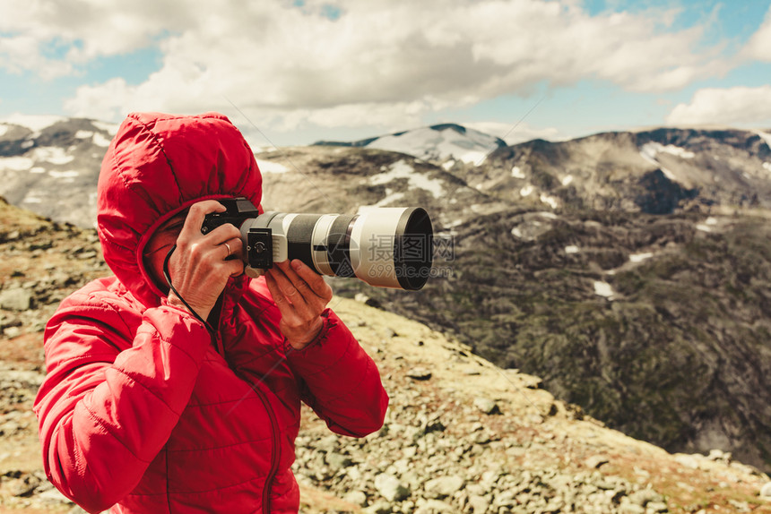 女游客用照相机享受来自挪威Dalsnibba地区的山风景图片