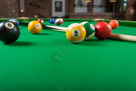 Billiard球和杆粘在绿色桌上池球游戏史努克和坚持在台桌上图片