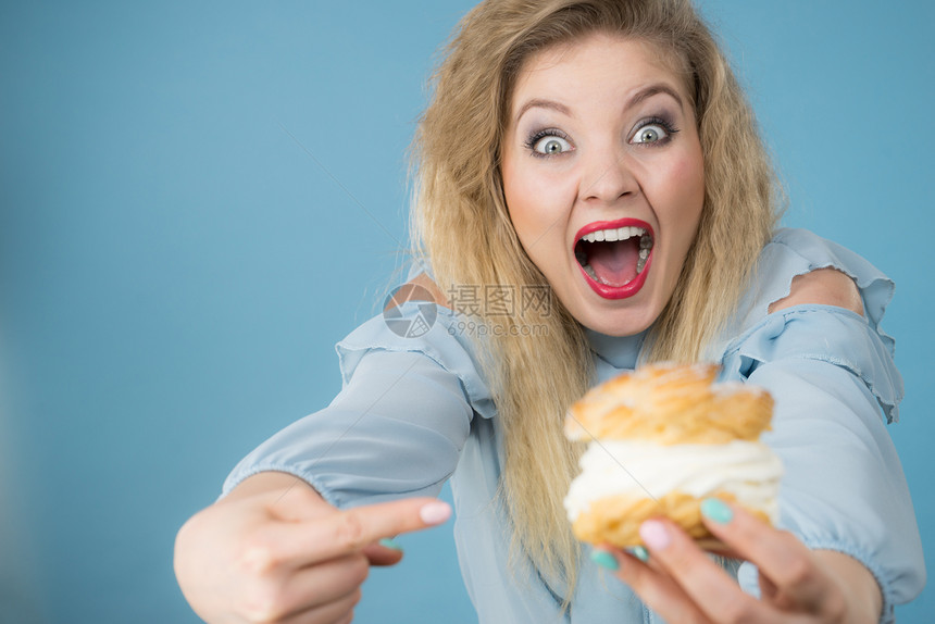 甜美的食物和幸福概念有趣是快乐金发女人拿着美味甜饼蛋糕奶油兴奋的面容表情蓝色的有趣女人拿着奶油蛋糕图片