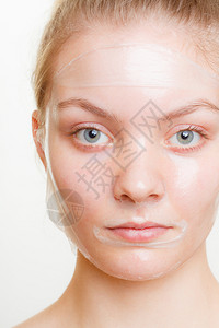 脸部剥皮的年轻女面部剥皮的年轻女肤美容和护理工作室拍摄灰色图片