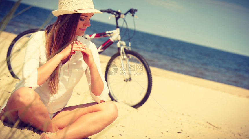 骑自行车在海滩上休息的美女图片