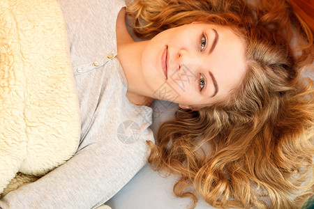 睡着后早上在床醒来的女人肖像年轻女孩躺在羊毛毯下图片