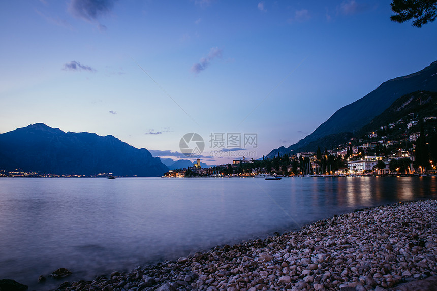 海滩上美丽的夜晚景色与可爱的小村庄意大利拉戈迪加达图片