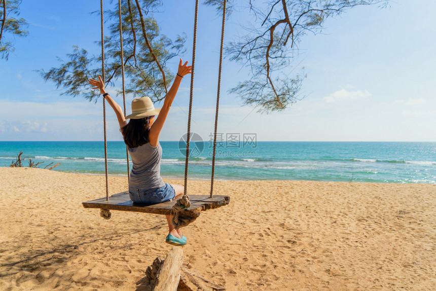 快乐的亚洲女在泰国普吉中午的海洋或自然户外度假旅行中在海滩上摇晃图片