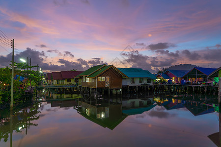泰国传统亚洲渔村的反射泰国普吉市农村地区日落背景的浮动房屋图片