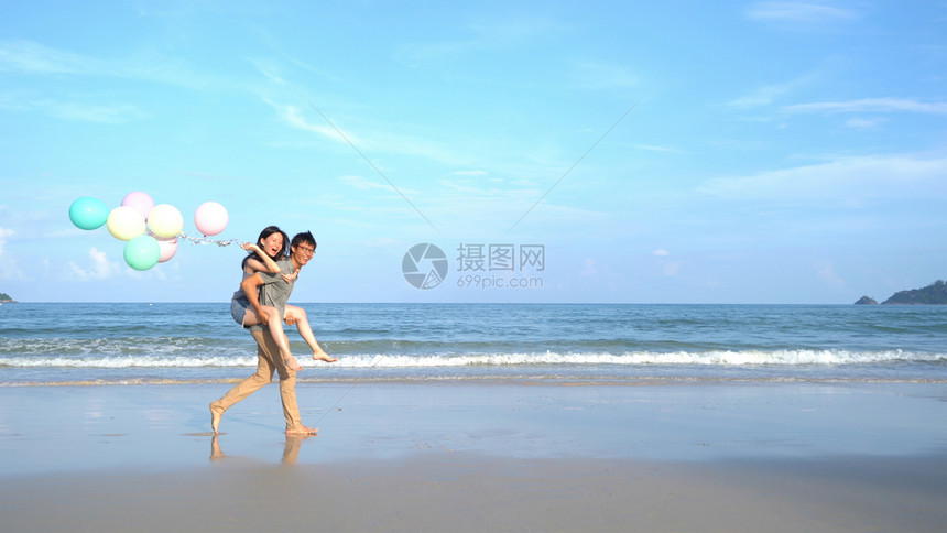 在泰国普吉岛海滩拿着气球玩耍的情侣图片