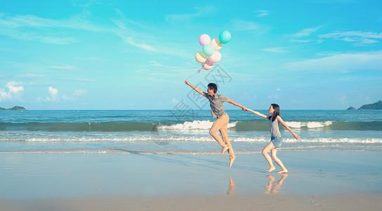 海滩女孩红气球快乐的亚洲情侣在泰国普吉Phucket中午的海洋或自然度假室外旅行时在海滩上持有彩色气球背景