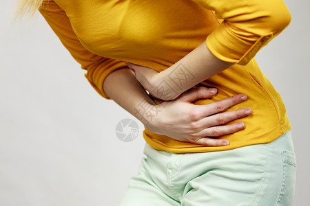 坚强的女人保健概念Bellyache消化不良或月经年轻女患灰色腹痛的胃女腹背景