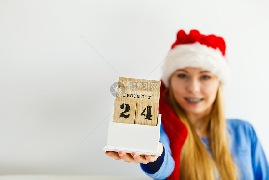 穿着圣诞老人礼帽的快乐年轻少女持有12月4日的历图片